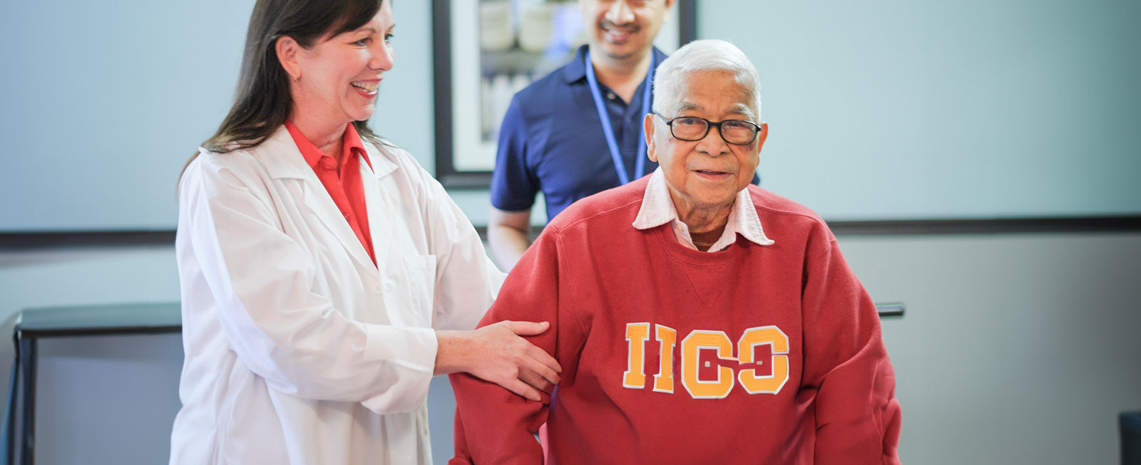 Staff helping man with rehab exercise