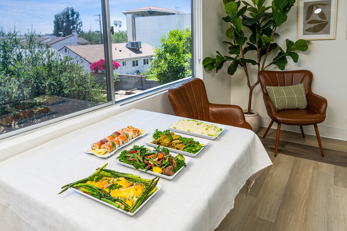 Table set with various dishes and a cozy chair.
