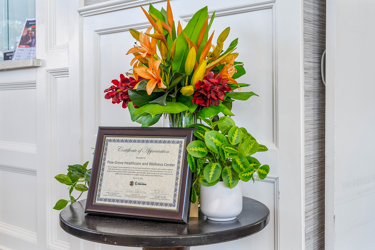 Certificate of appreciation with flowers on a table.