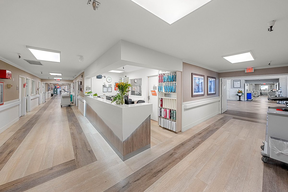 Bright hospital hallway with a reception area and offices.